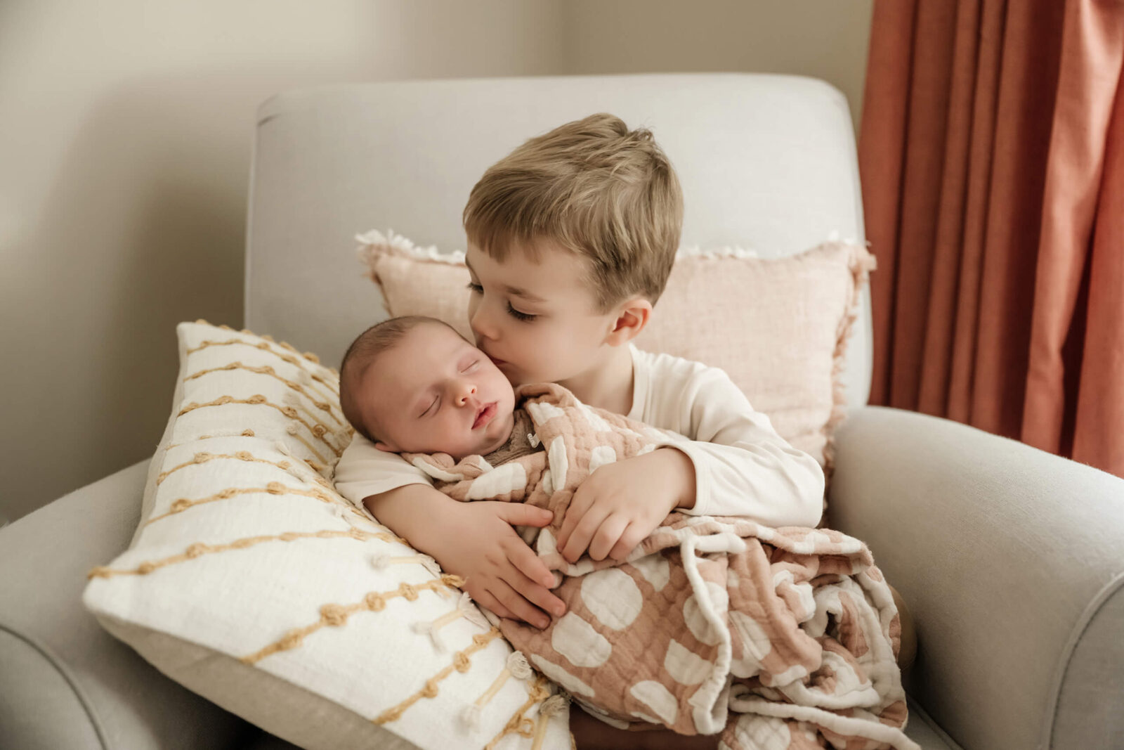 Newborn with sibling moment during photoshoot at home